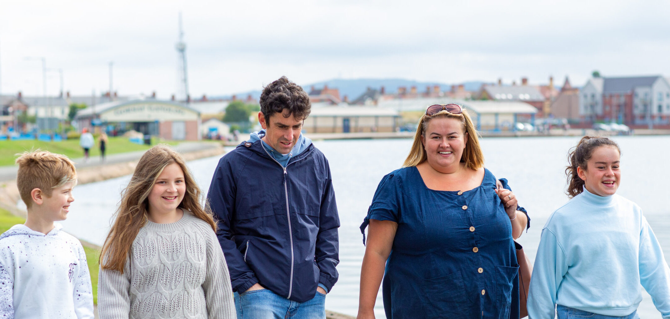 A family of 5 walking and looking happy in Denbighshrie
