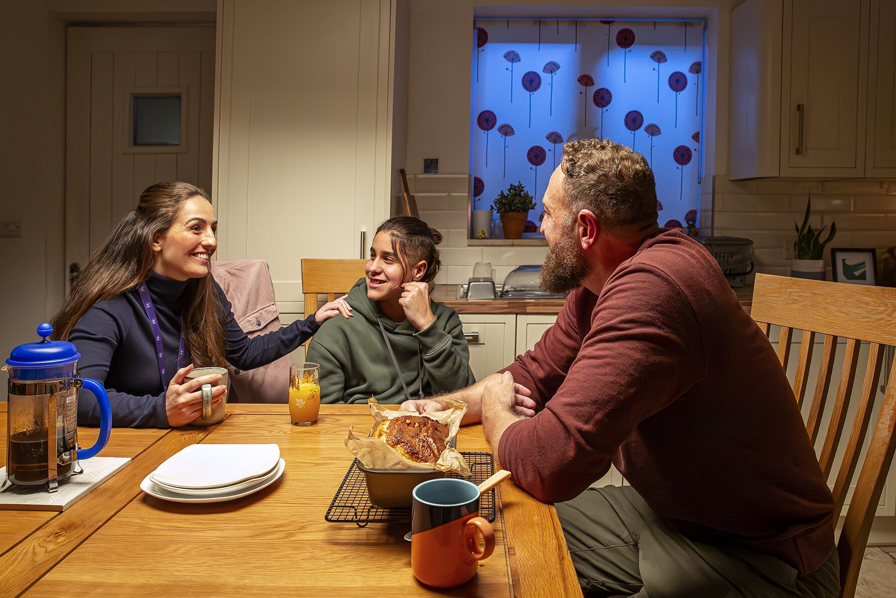 social worker, young person and foster carer chat around table